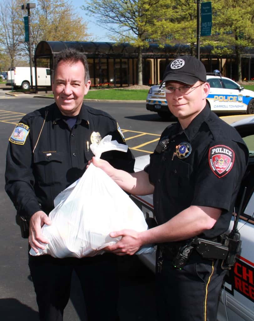  Carroll Twp. Police Chief Paul Brand and Officer Ryan Brand of Charleroi display one of the bags of drugs donated to the 6th National Drug Take Back Day in April. 