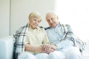 Portrait of cheerful senior couple sitting at home
