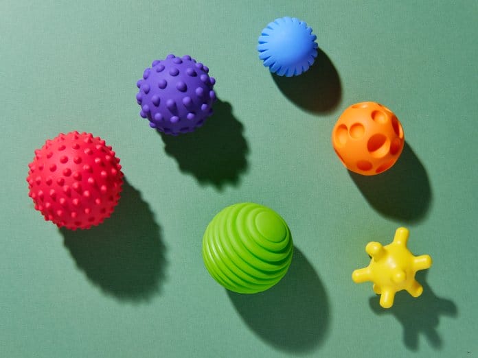 A set of five different types of sensory processing activity balls. They are spiked, dented, textured, and ribbed.