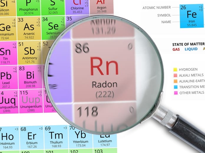 A section of the periodic table of elements with a magnifying glass enlarging the Rn (Radon) square.